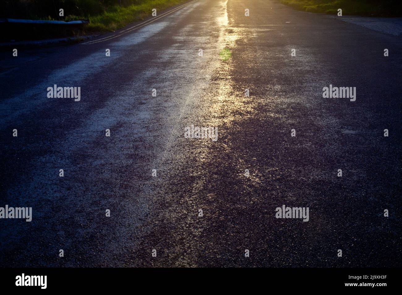 abstract photograph using a long exposure and filter looking into the  strong summer sunlight shining brightly down a road Stock Photo