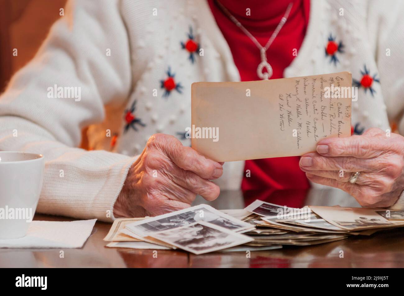 Elderly woman holding an old picture and reminiscing Stock Photo