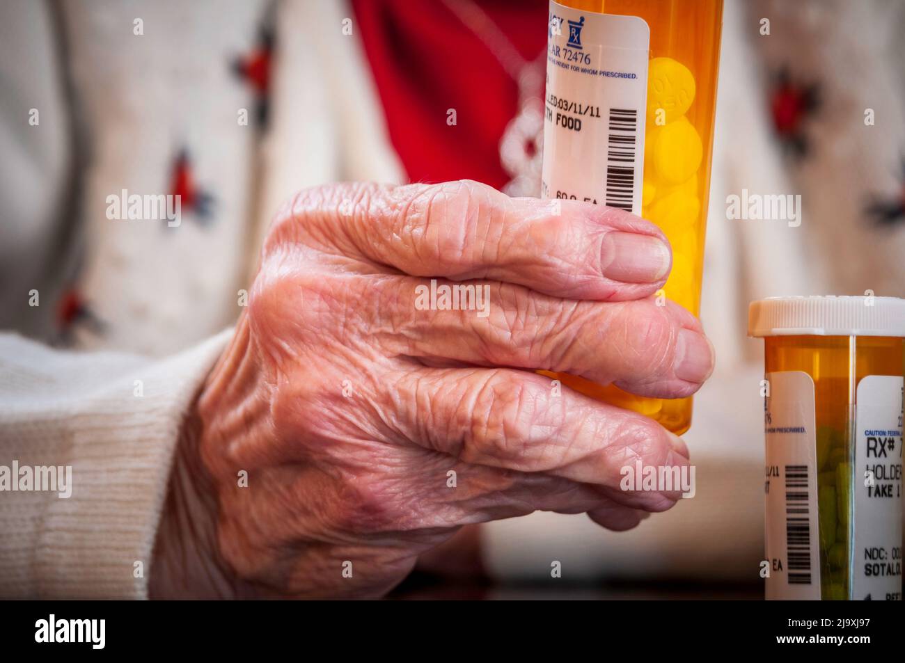 Elderly woman holding a pill bottle of prescription medication Stock Photo