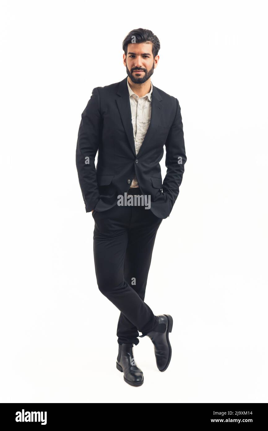 Handsome businessman standing cross-legged with his hands in his pockets, vertical. High quality photo Stock Photo