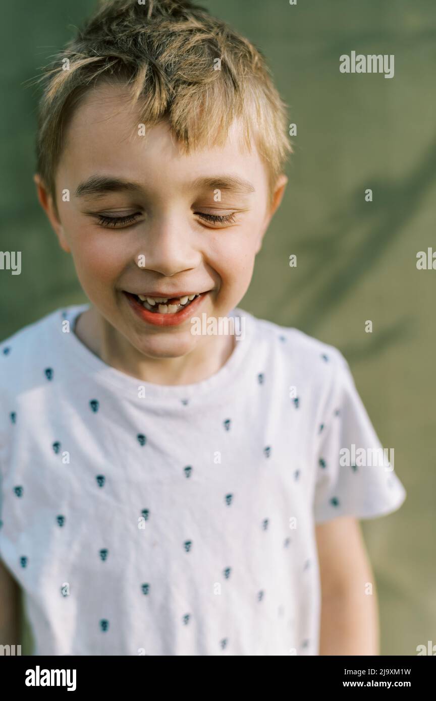 Portrait of young boy with missing teeth smiling big Stock Photo