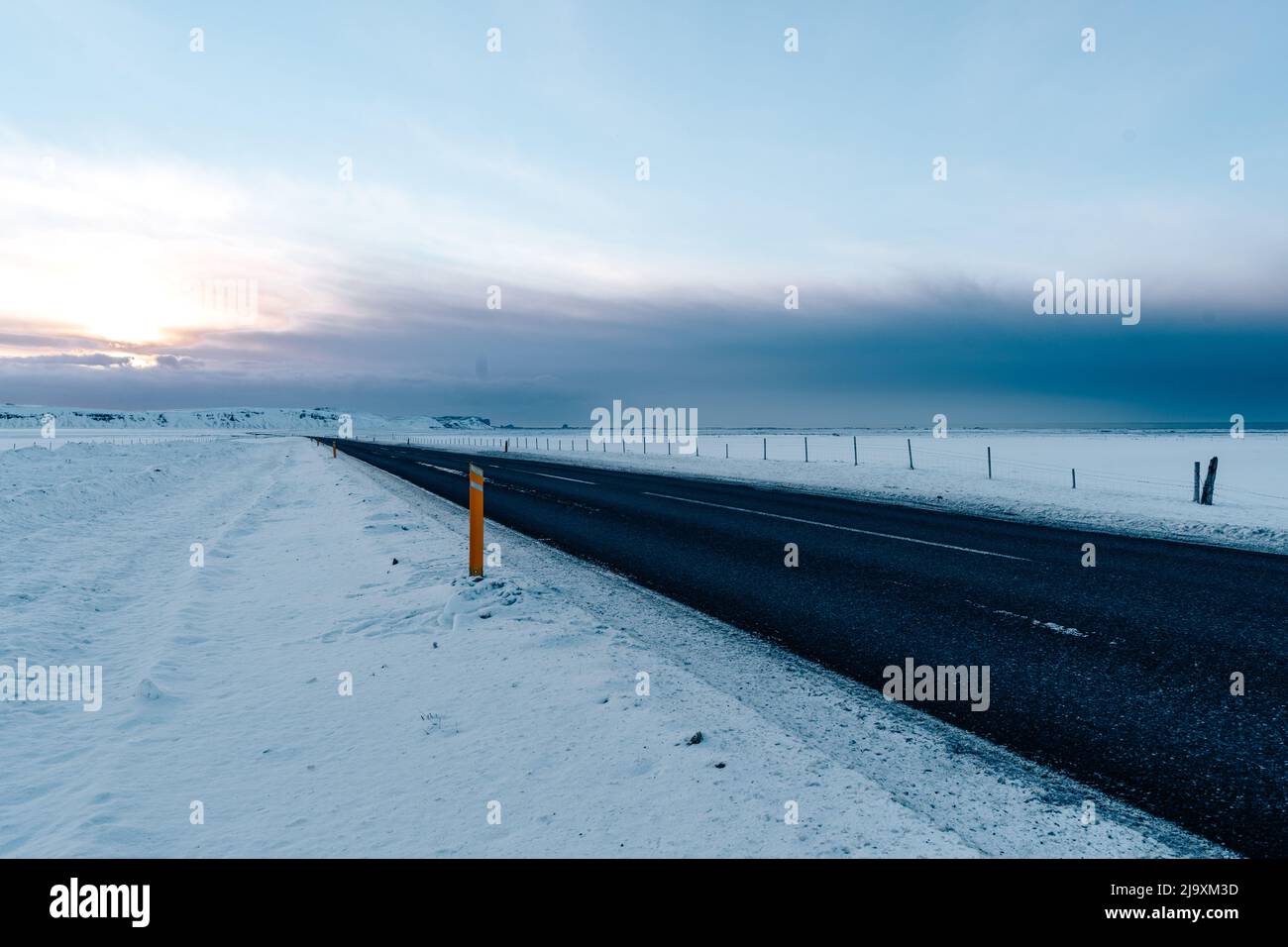 Asphalt road with snow-covered roadsides Stock Photo