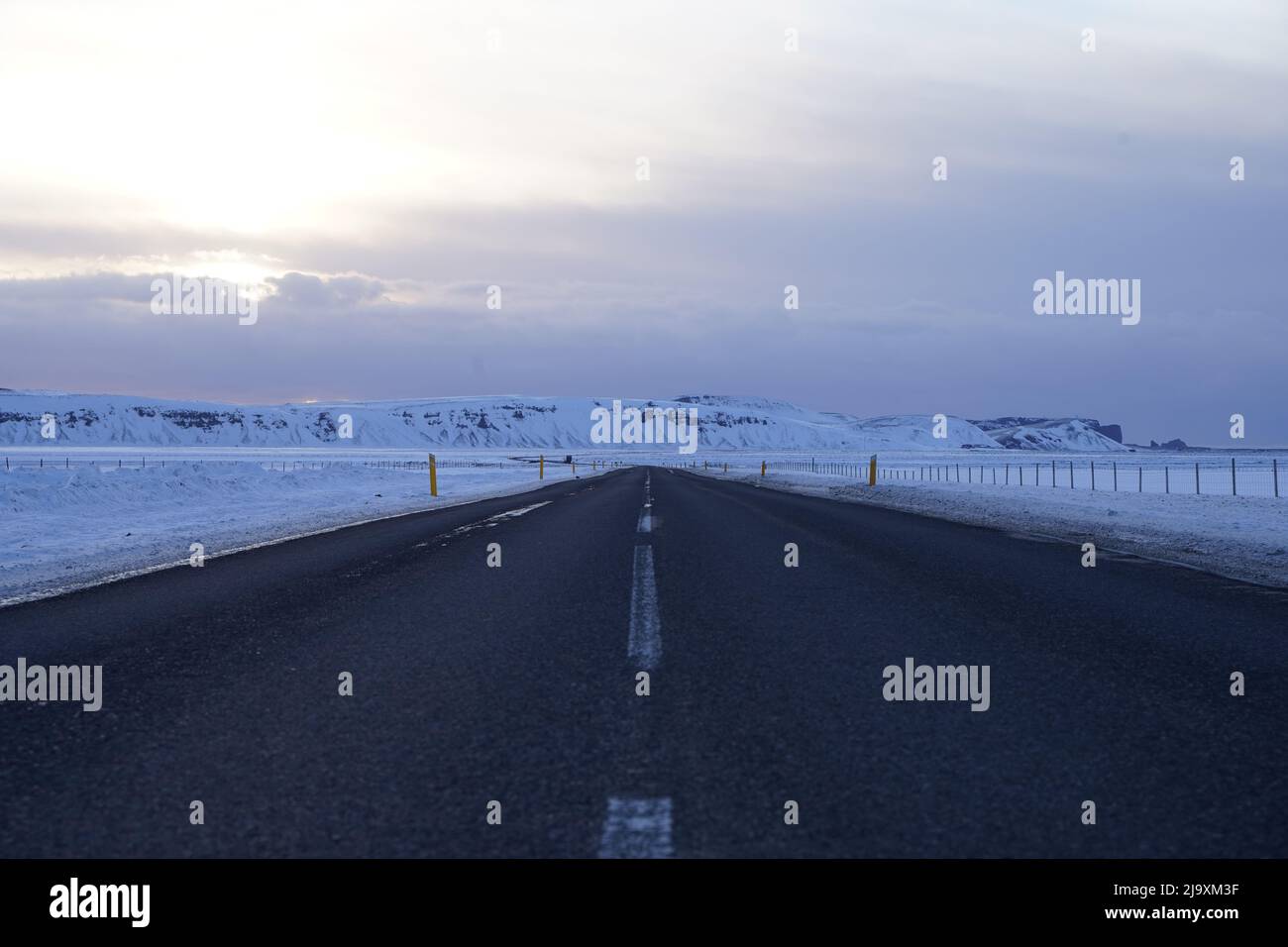 Asphalt road with snow-covered roadsides Stock Photo