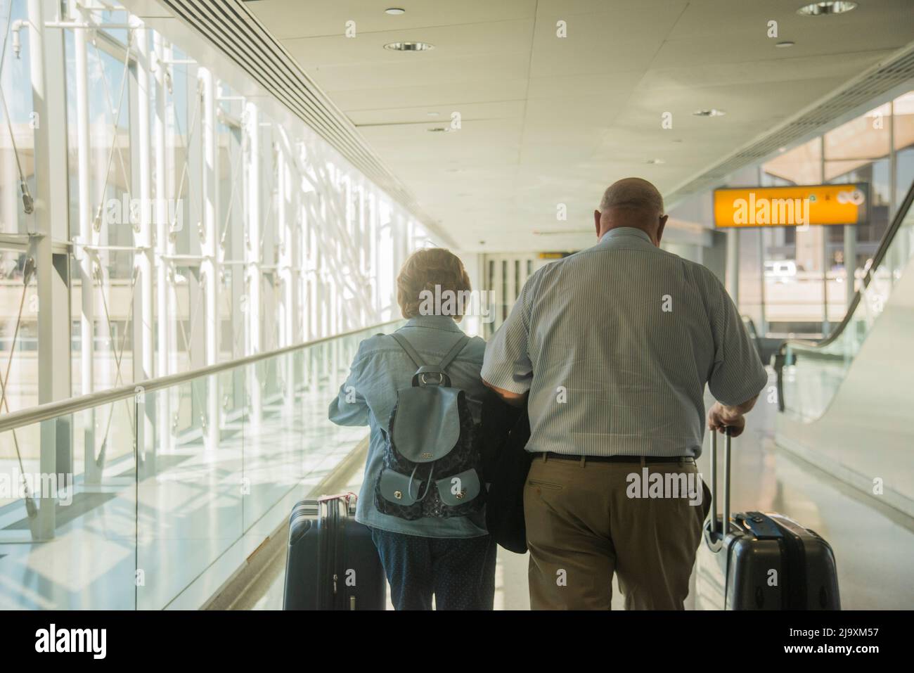 Traveling Seniors Walking Through Airport Stock Photo Alamy