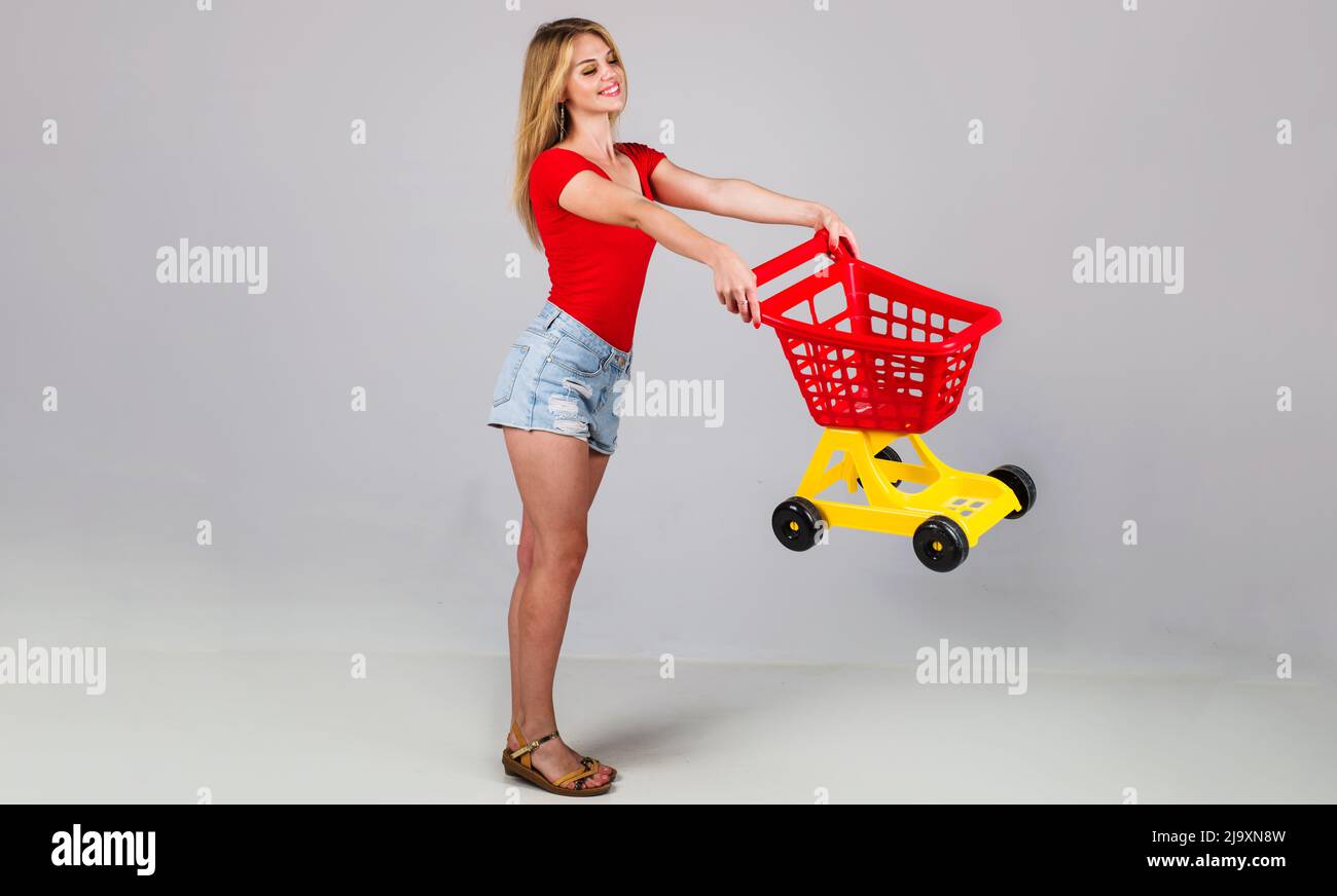 Happy woman with empty shopping trolley. Buyer in supermarket. Sale. Discount. Black friday. Buying. Stock Photo