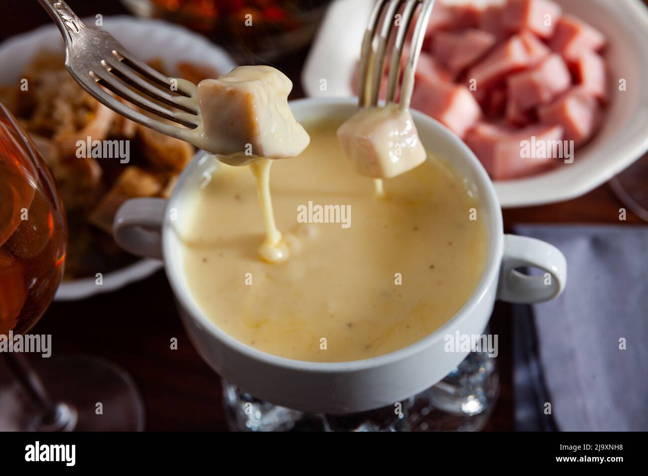 Swiss cheese fondue with bread, sausages and wine Stock Photo Alamy