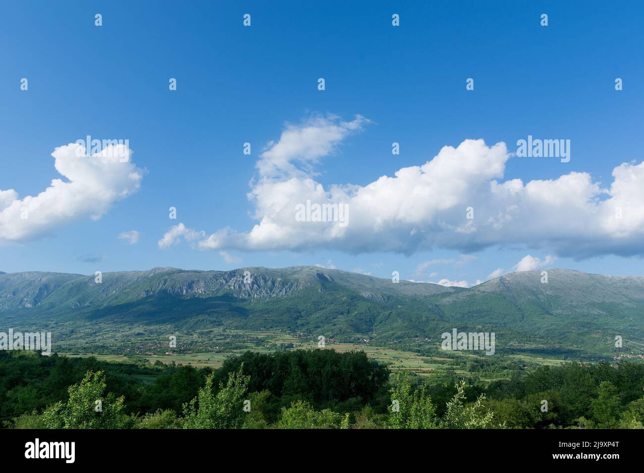 Panorama of mounts of the Suva Planina, a chain of mountains and hills in Serbia, with forests, hills and agricultural fields on a spring sunny day Stock Photo