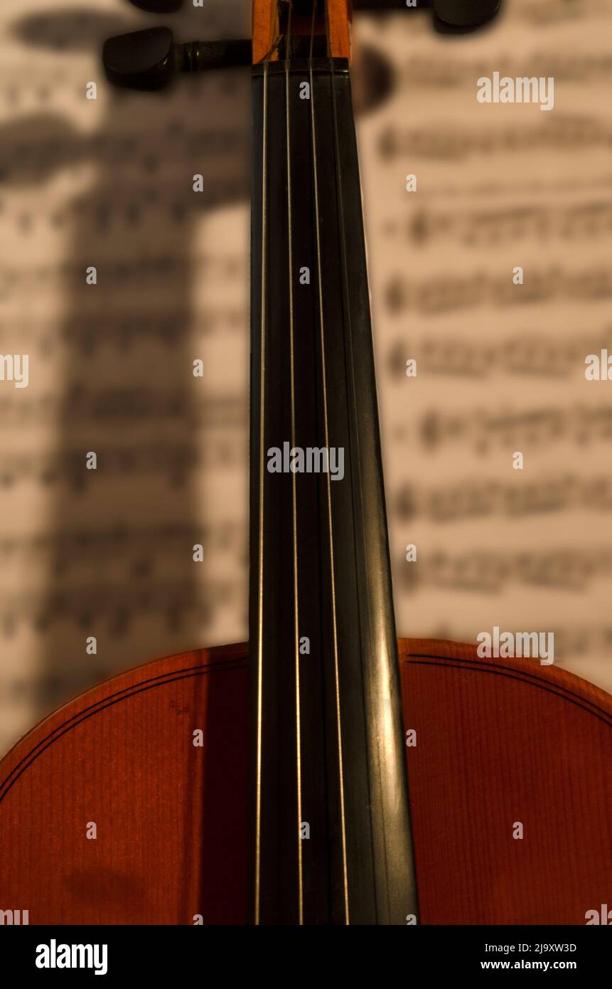 violin with sheet music behind. Classical or chamber wood violin