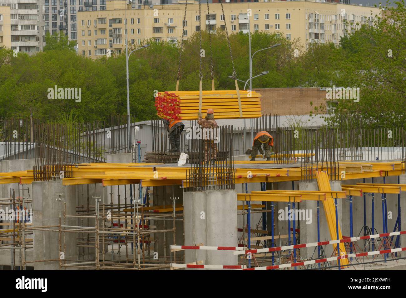 Crane supplies blanks for formwork to builders in house under construction. MAY 21 2022 MOSCOW RUSSIA Stock Photo