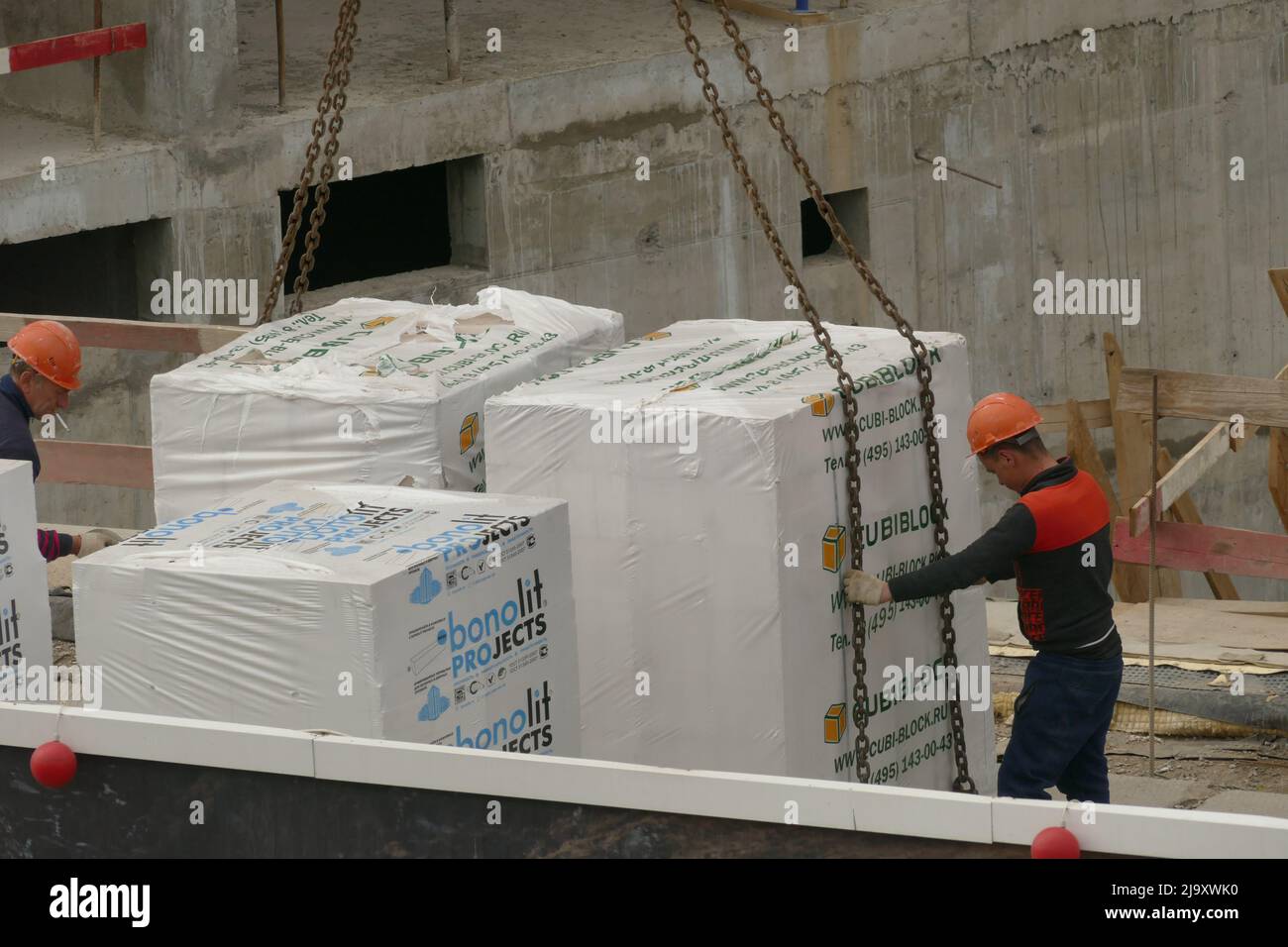 Slingers fasten a pallet with stone blocks for carrying it with a crane MAY 21 2022 MOSCOW RUSSIA Stock Photo