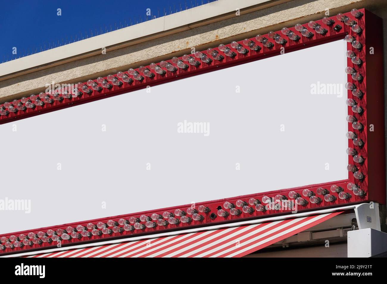 Blank white store sign with lights all around the border on a red