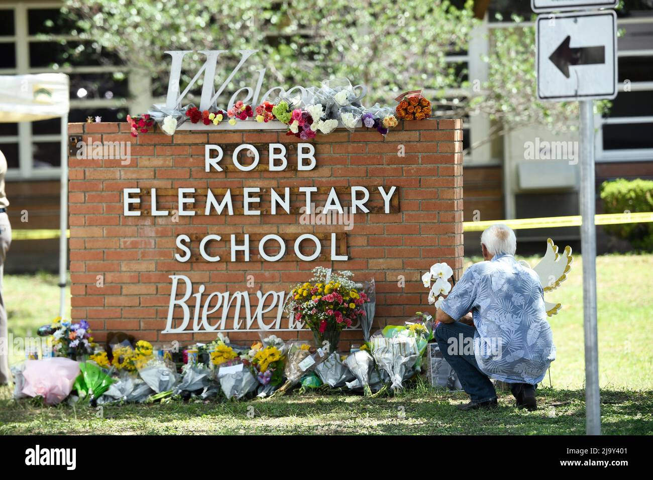 Uvalde, United States. 25th May, 2022. A local resident places flowers outside Robb Elementary school in Uvalde where a lone gunman killed 19 schoolchildren and 2 teachers on May 24, 2022 Credit: Bob Daemmrich/Alamy Live News Stock Photo