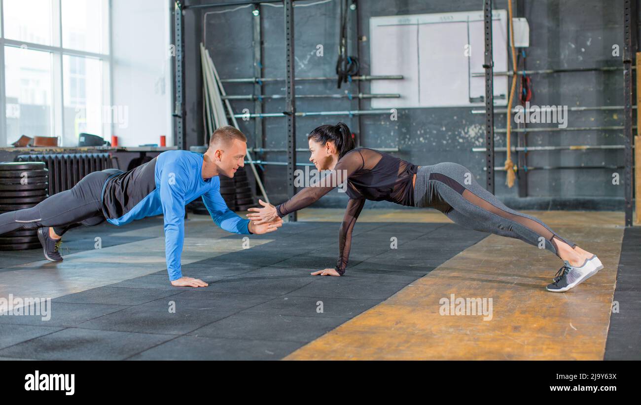 Sporty couple doing push ups together and giving vife. Active and ...