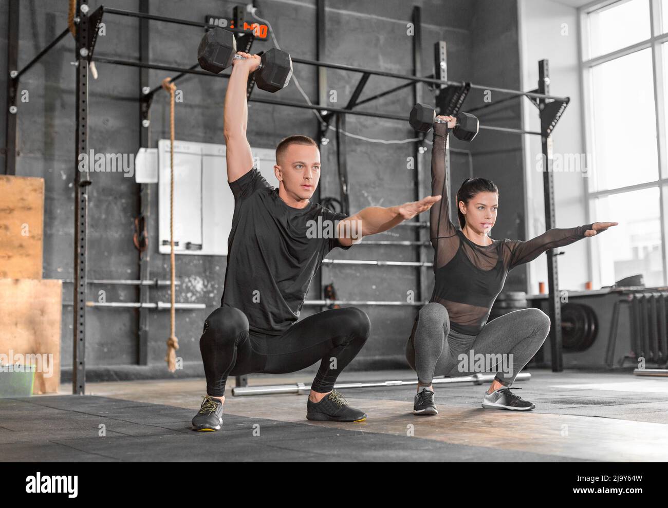 Fitness couple in gym working out together. Teamwork concept. Stock Photo