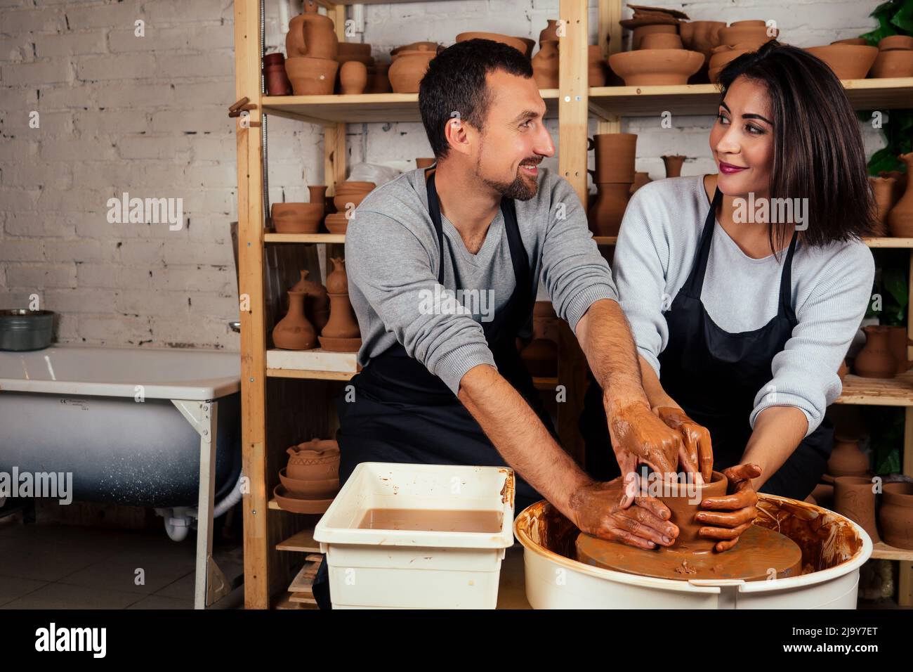 handsome man and happy woman couple in love working on potter wheel ...