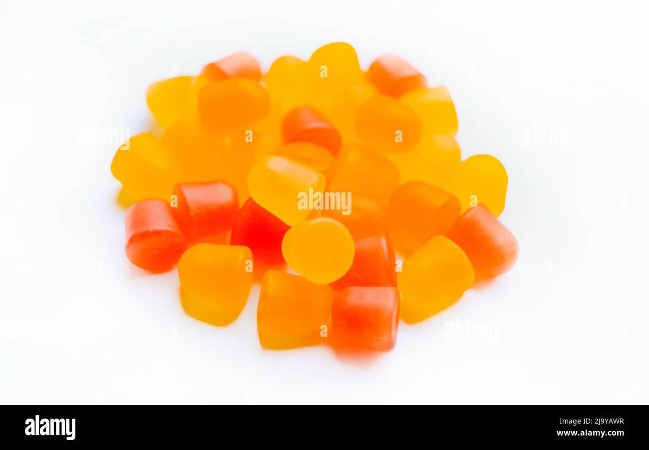 Close-up texture of orange and yellow multivitamin gummies in the form of bears on white background.  Stock Photo