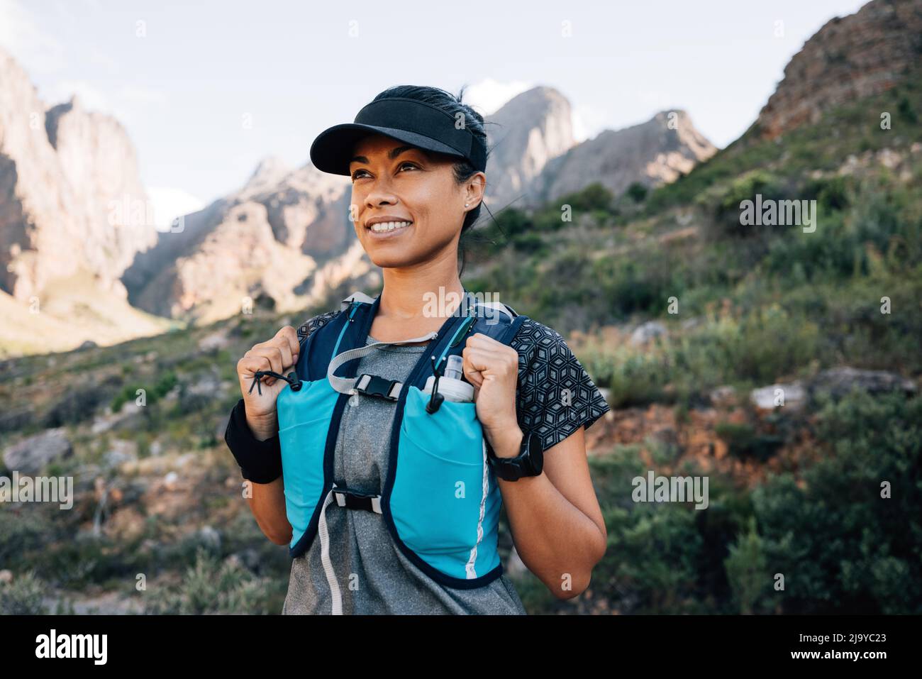 Portrait of a smiling woman in hiking attire looking away while standing in  the valley Stock Photo - Alamy