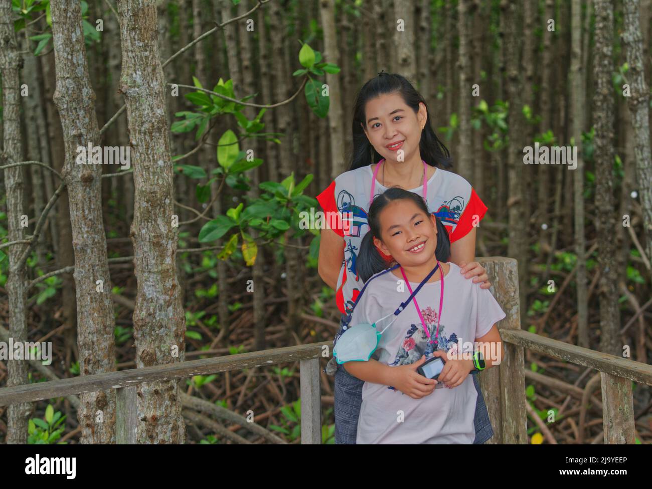 Asian middle-aged mother and little daughter travel to Kung Krabaen Bay Mangrove Study Center of Thailand. The concept for education traveling. Stock Photo