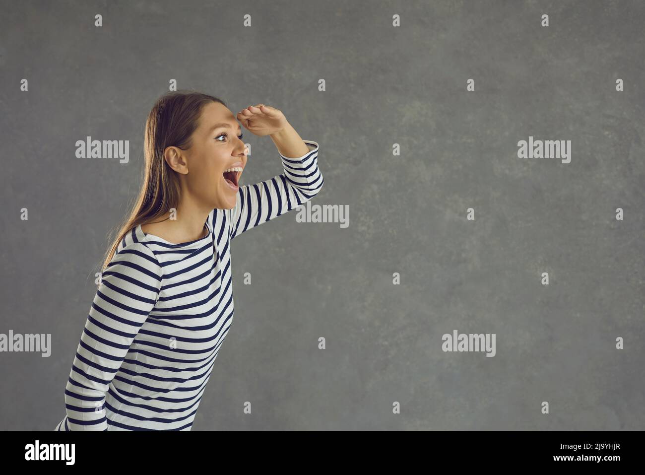 Happy woman holding hand on forehead and looking in distance on copy space background Stock Photo