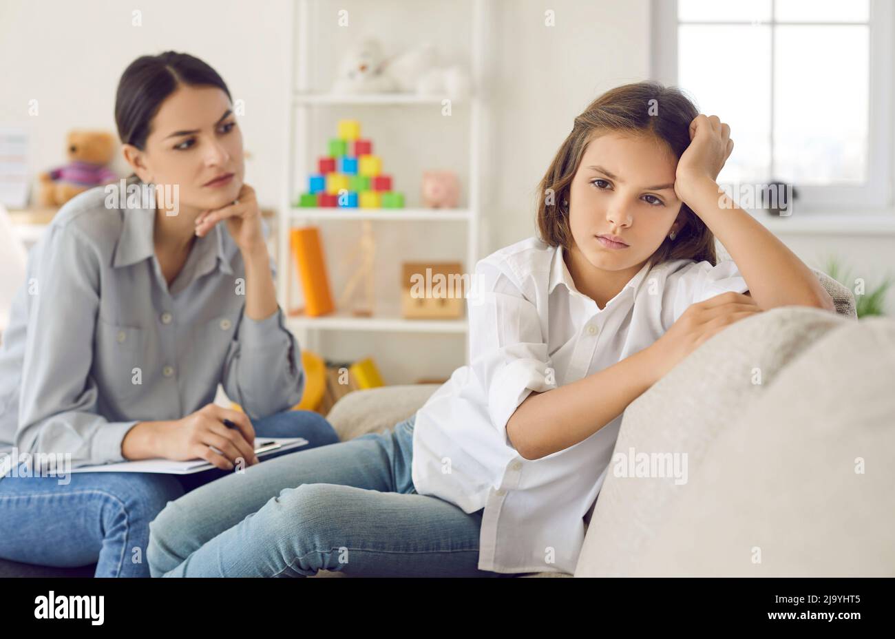Unhappy child at psychologist's office not ready to talk about problems and emotions Stock Photo