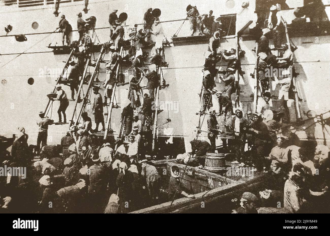 Japan   -  An old illustration showing workers described as  'Japanese Coolies' using ladders to fuel a large ship with coal by hand  using  baskets at Yokohama, circa 1930s  ------   日本 - 1930年代頃、横浜でバスケットを使って石炭を手作業で石炭で燃やすためにはしごを使った「日本のクーリー」と表現された労働者を示す古いイラスト Stock Photo