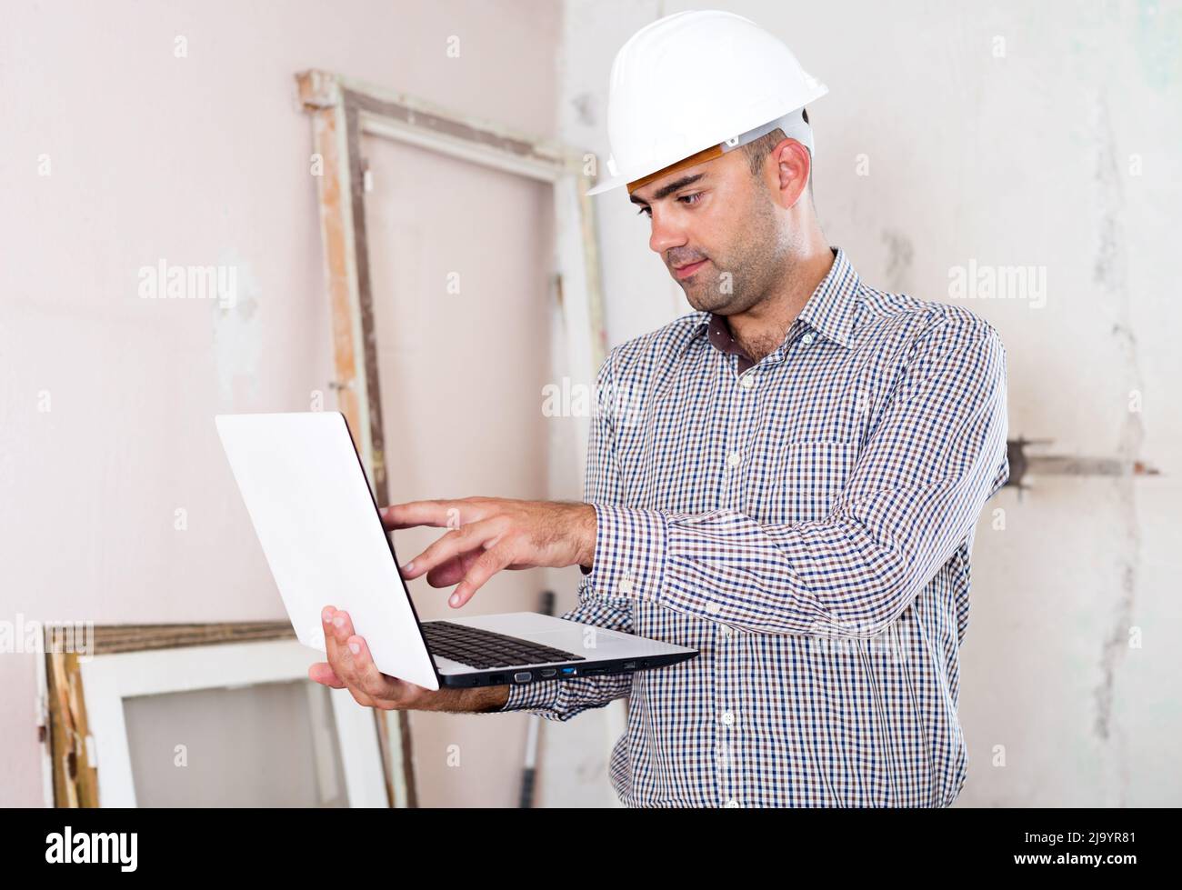 Man engineer managing process with laptop Stock Photo