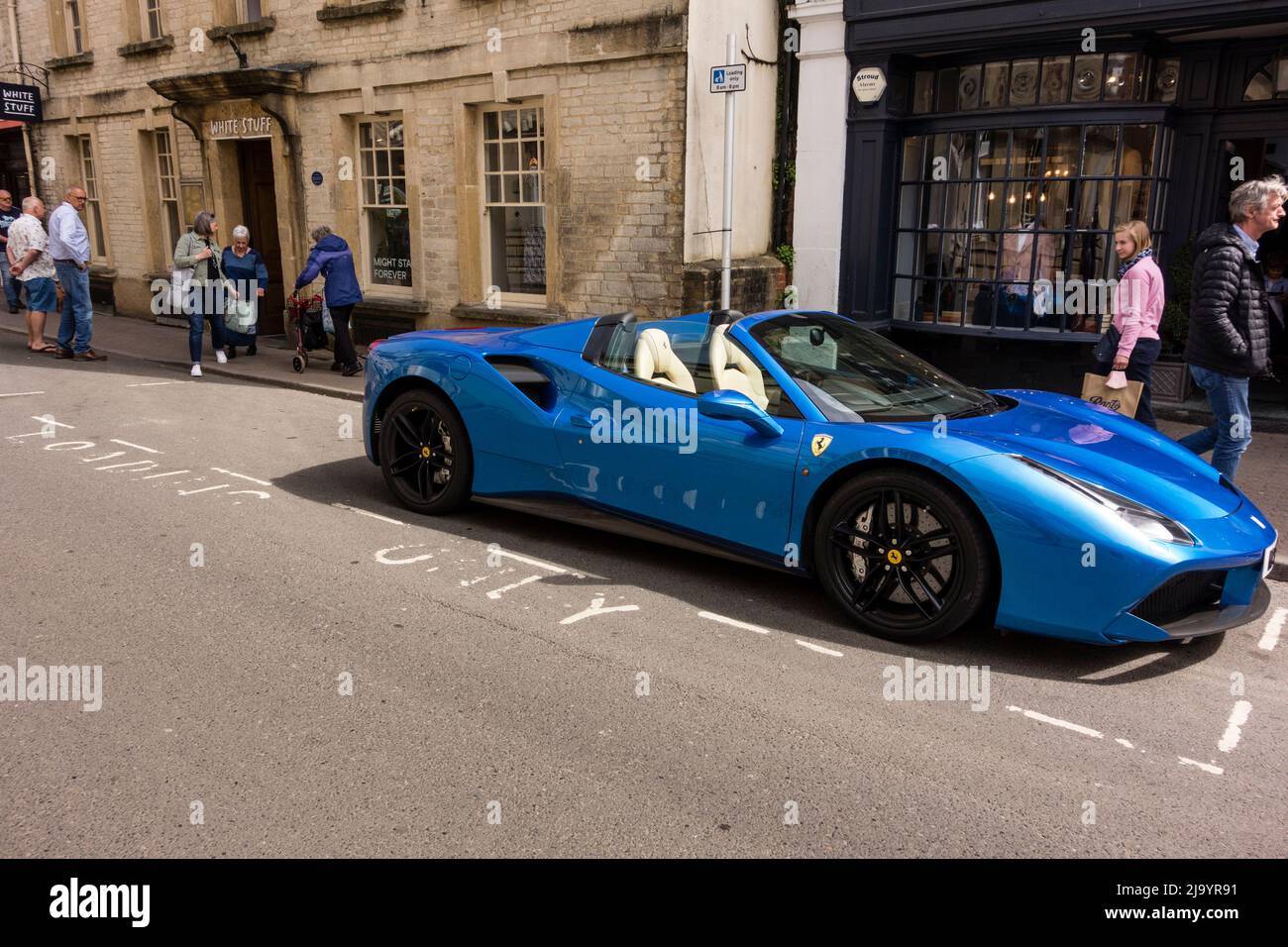 Blue Ferrari  luxury sports car parked in Loading Only marked area, Cirencester, Gloucestershire, UK Stock Photo