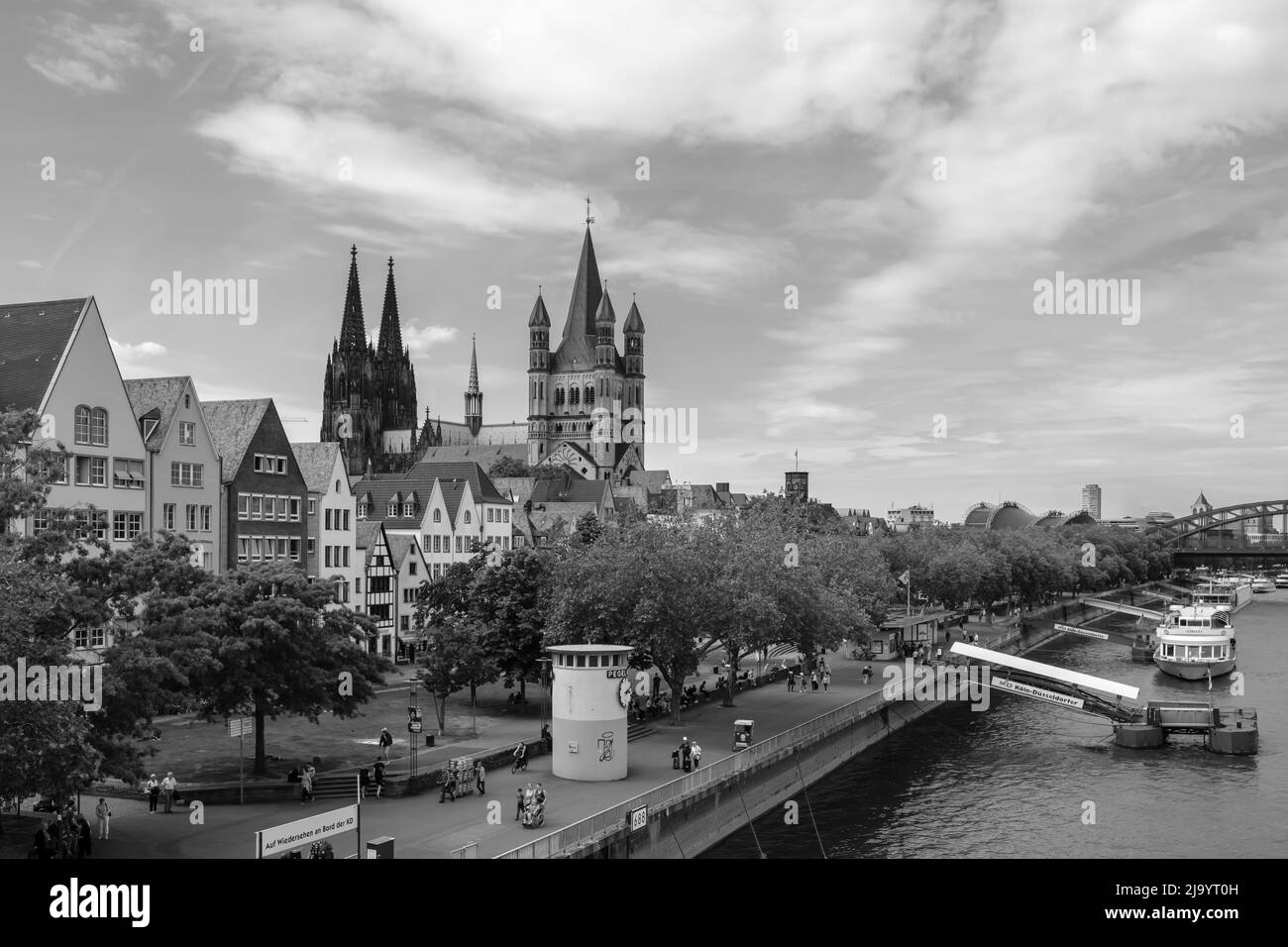 Cologne, Germany - May 17, 2022 : Panoramic view of the cathedral Saint Martin, the Dom and people walking next to the river Rhine of Cologne in black and white Stock Photo