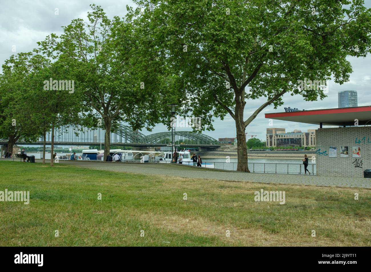 Cologne, Germany - May 17, 2022 : People walking next to the river Rhine on a cloudy day in Cologne Stock Photo