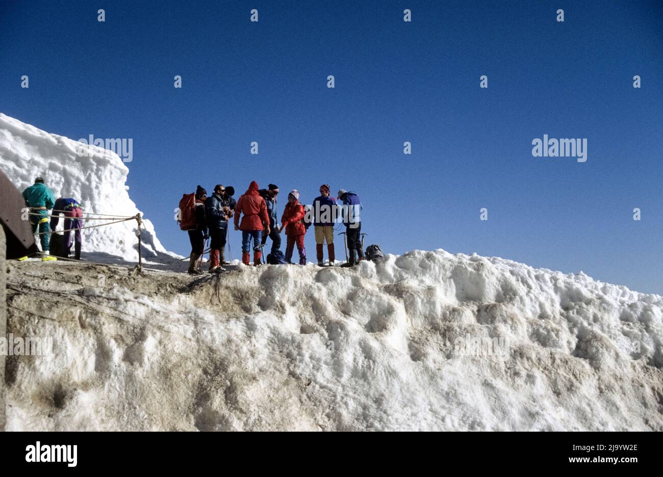 On the Aiguille du Midi, a group of mountaineers prepare for a glacier hike. Chamonix Mont Blanc, France, 1990 Stock Photo