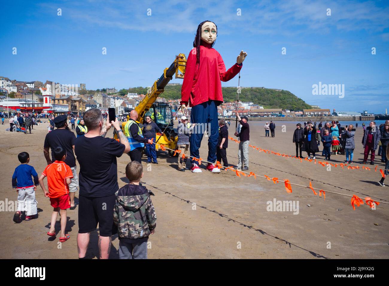 People watching Aura the puppet being operated on Scarborough beach during a performance of the Survivor Stock Photo