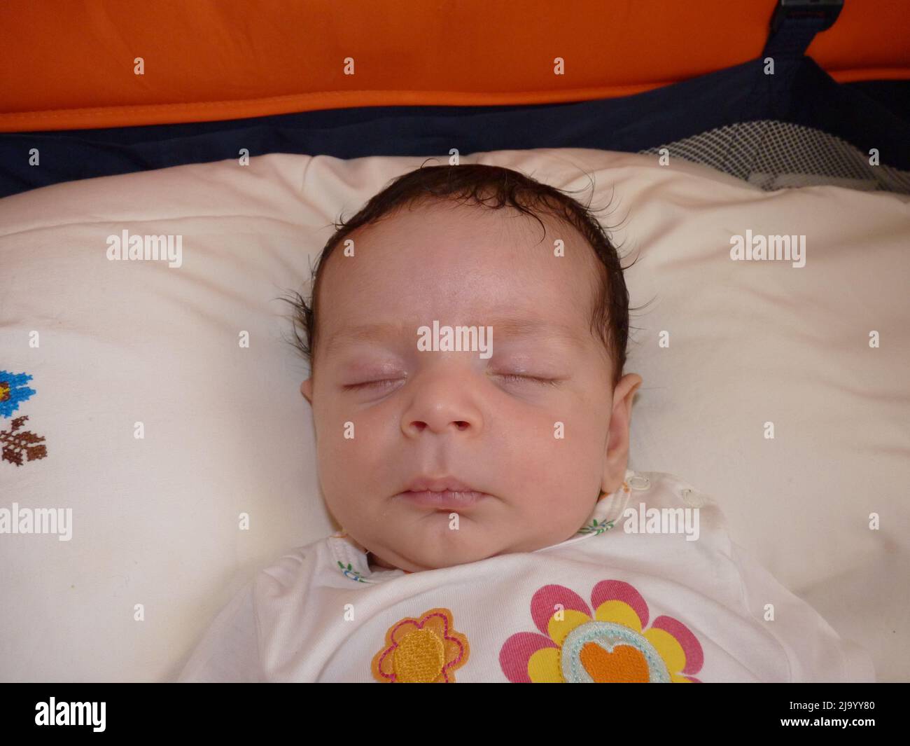 newborn baby sleeps in crib. He has gloves so he doesn't scratch his