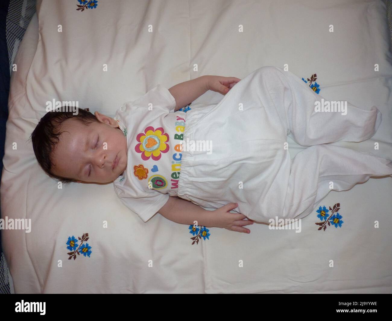 newborn baby sleeps in crib. He has gloves so he doesn't scratch his