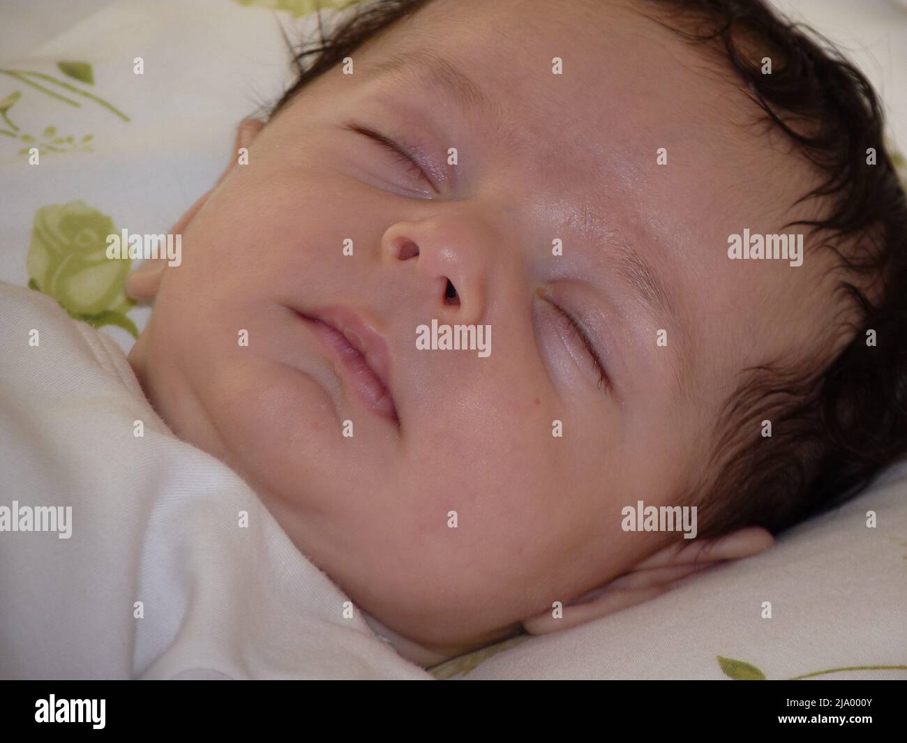 newborn baby sleeps in crib. He has gloves so he doesn't scratch his face Stock Photo Alamy