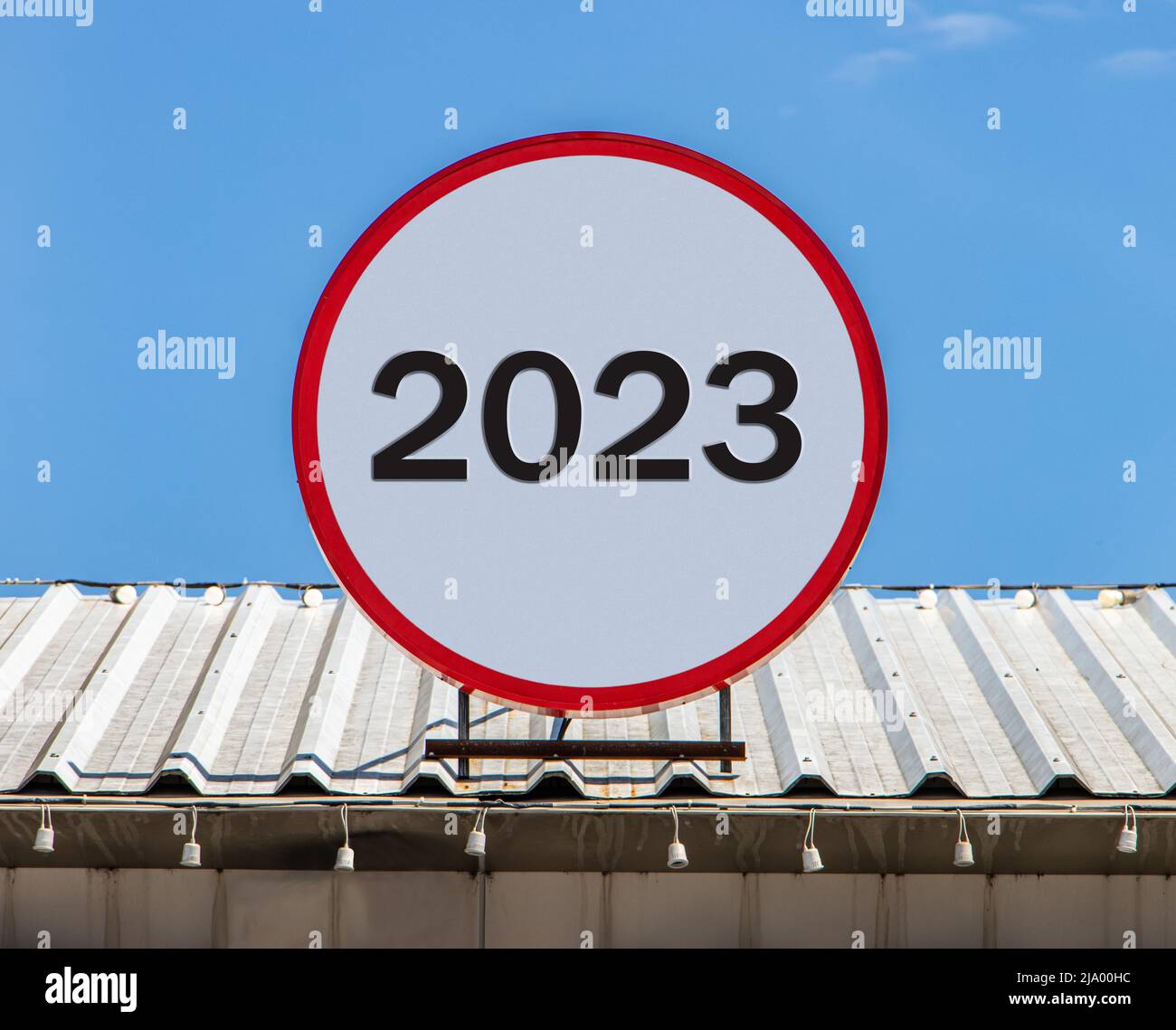 A Circle billboard with number 2023, is installed on a roof. Greeting for New Year 2023. Stock Photo