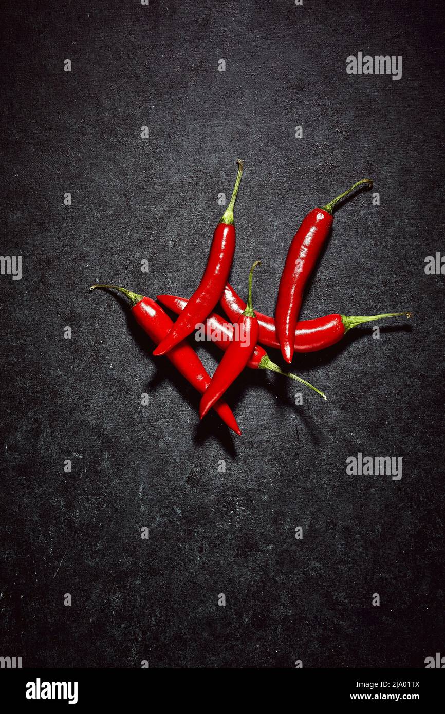 Group of red hot spicy vegetables. High angle view of chilli peppers on  dark blue background. Spicy ingredients in kitchen Stock Photo - Alamy