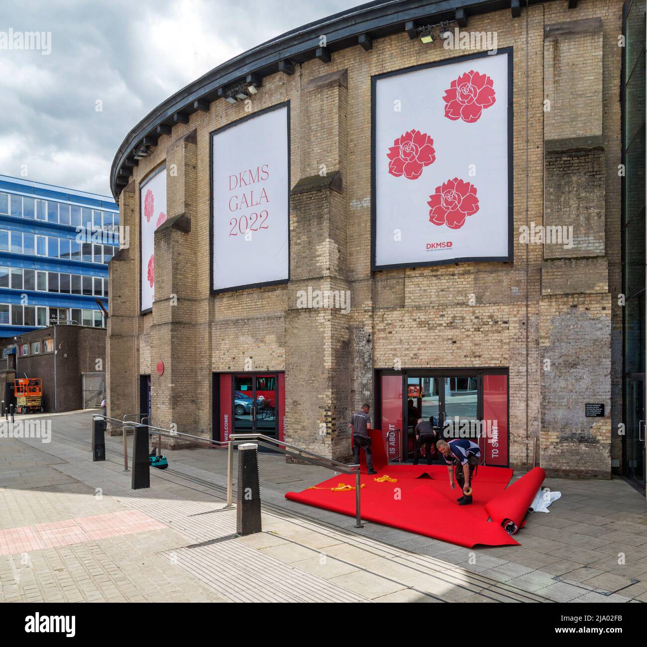 A red carpet being laid in preparation of the stars and VIPs arriving at the Roundhouse Theatre for the DKMS Gala. Stock Photo