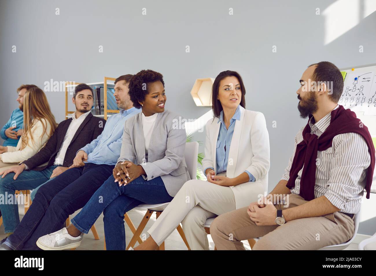 Different groups of people communicate with each other during business seminar or training. Stock Photo