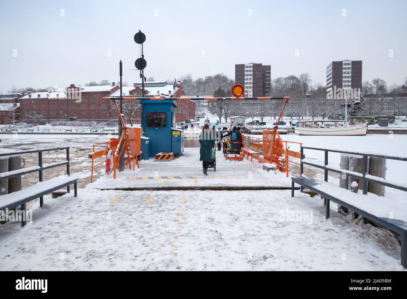 Turku, Finland - January 17, 2016: Ordinary passengers loading on small city boat Fori, a light traffic ferry that has served the Aura River for over Stock Photo