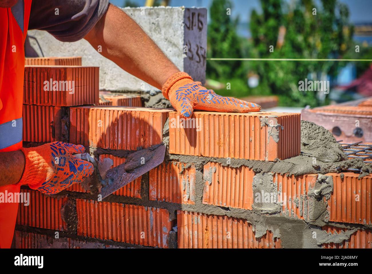 Close up of industrial bricklayer installing bricks on construction site. worker with bricks Stock Photo