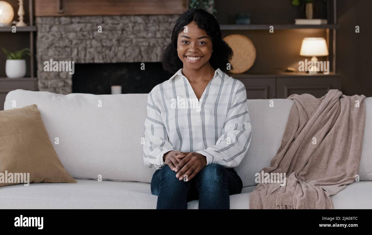African girl woman housewife homeowner female renter wife at home in living room smiling friendly looking at camera satisfied with buying new home Stock Photo