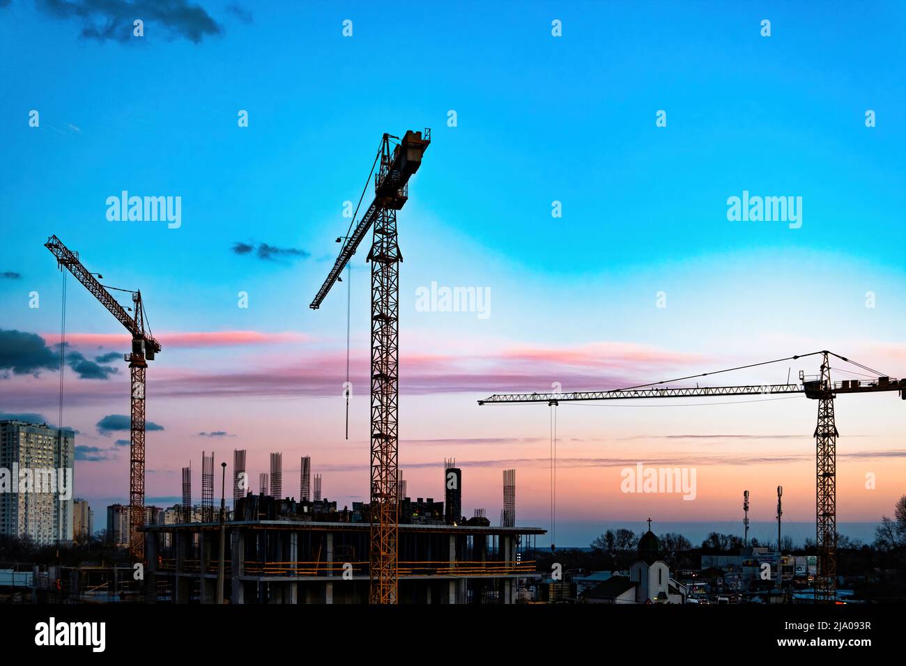 Construction site with crane. Silhouette cranes, industry concept over natural background sunset pastel. Production facility. The crane. Against the Stock Photo