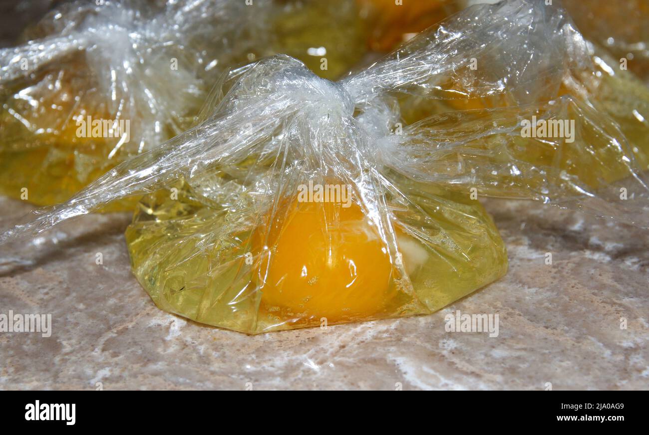 Close up view of eggs that were placed individually in plastic bags in order to make eggs benedict by a home cook. Stock Photo