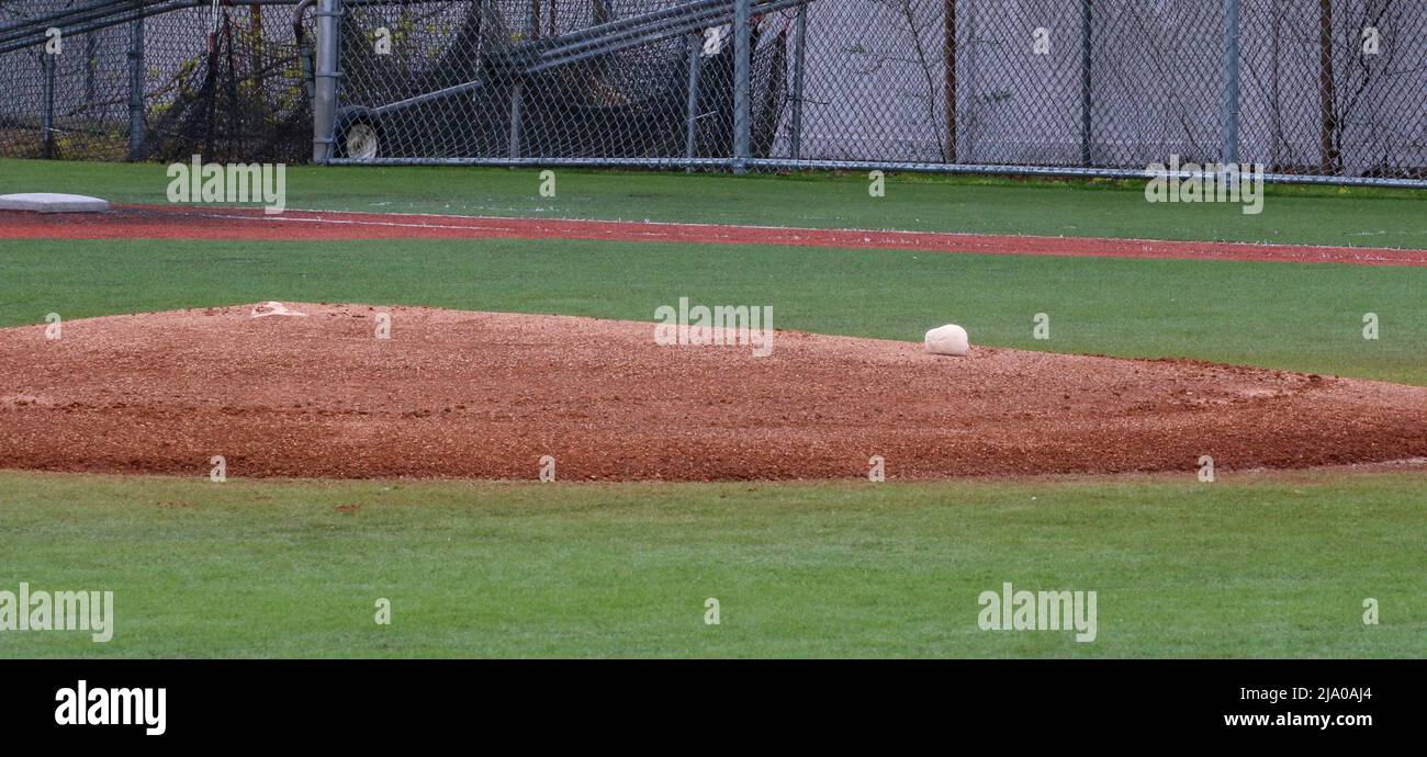 High schools baseball pitchers mound in a turf infield with a rosin bag