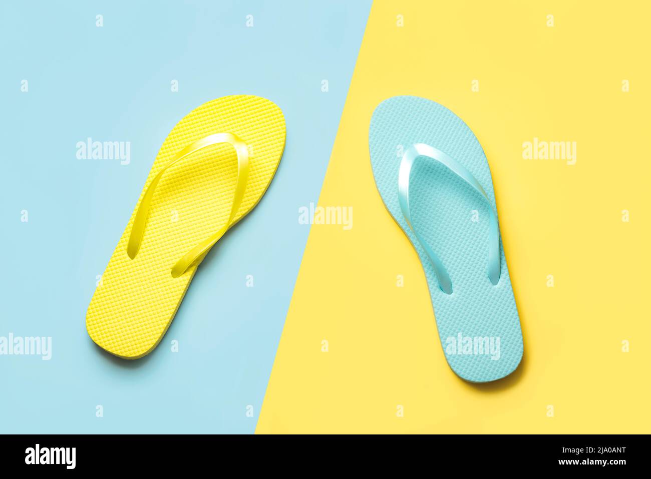 Summer holiday concept.Top view of colored beach flip flops over blue and yellow background Stock Photo