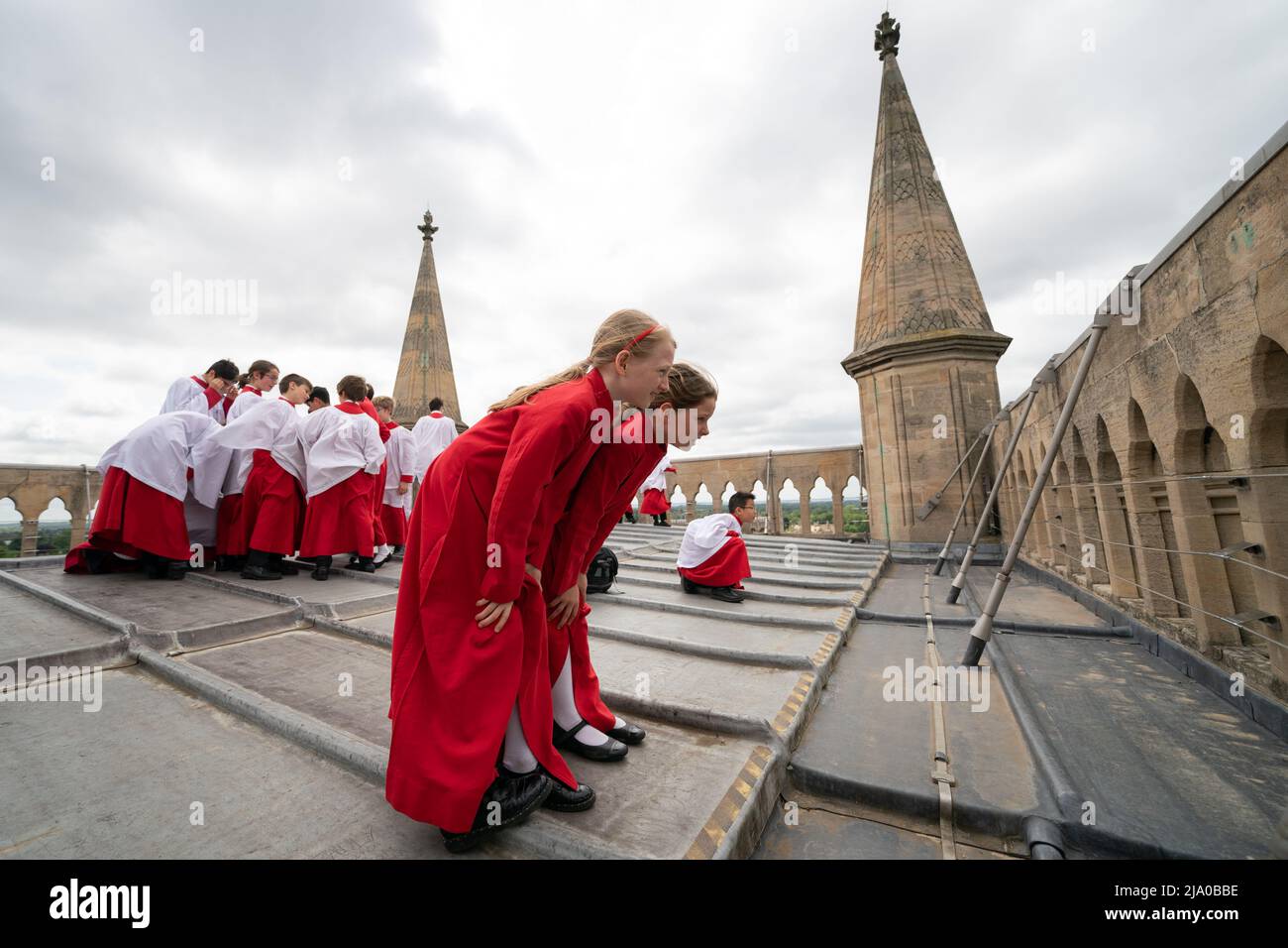 Choristers from the Choir of St John's College, Cambridge, take in the view before performing the Ascension Day carol from the top of the Chapel Tower at St John's College, a custom dating back to 1902. Picture date: Thursday May 26, 2022. Every year on Ascension Day the Choir ascends the 163ft Chapel Tower and sings the Ascension Day carol. This custom dates from 1902 and was begun by the then Director of Music, Cyril Rootham, following a conversation with Sir Joseph Larmor. Sir Jospeh was insistent that a choir singing from the tower would not be heard from the ground. Rootham was keen to pr Stock Photo