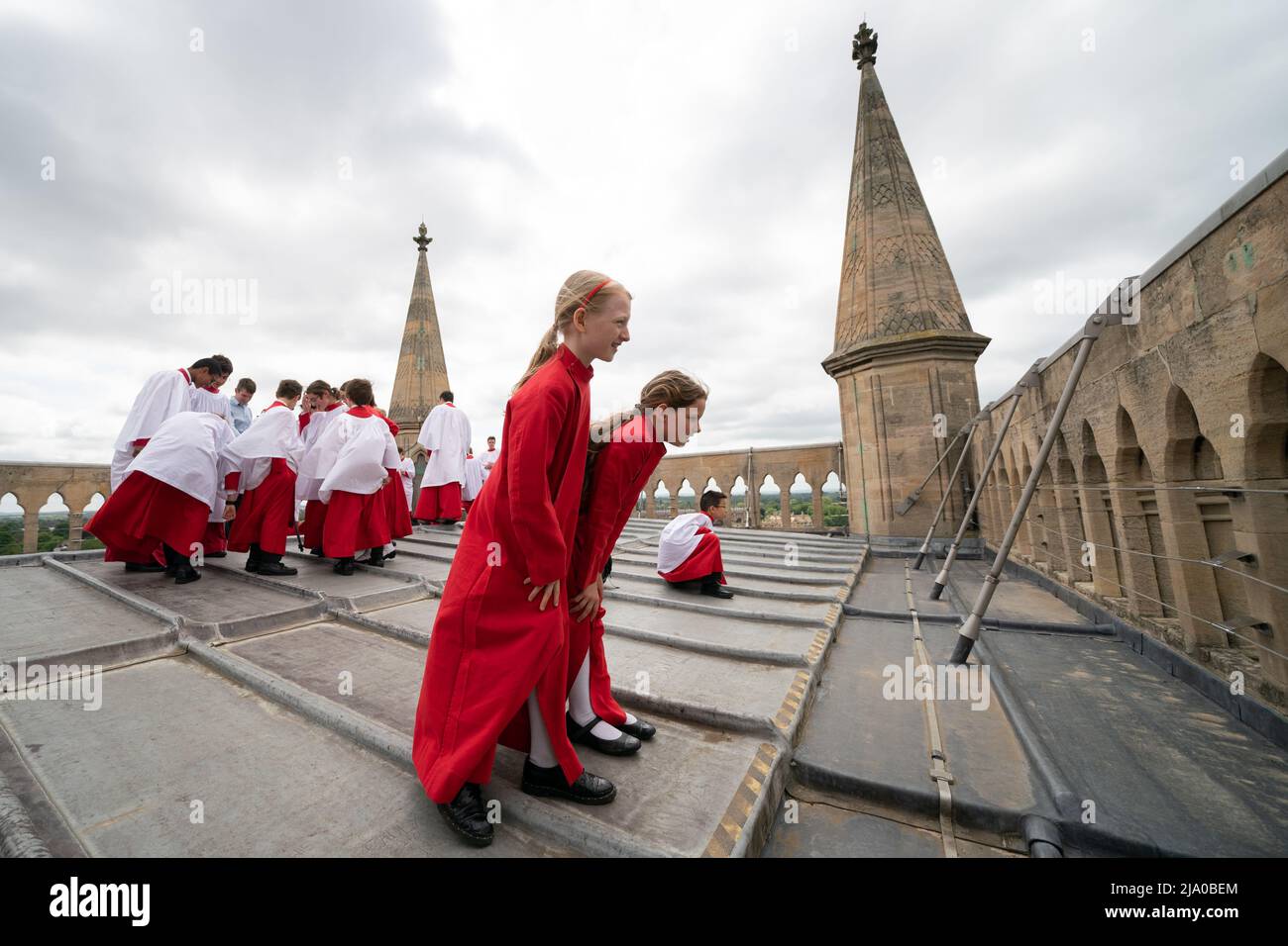 Choristers from the Choir of St John's College, Cambridge, take in the view before performing the Ascension Day carol from the top of the Chapel Tower at St John's College, a custom dating back to 1902. Picture date: Thursday May 26, 2022. Every year on Ascension Day the Choir ascends the 163ft Chapel Tower and sings the Ascension Day carol. This custom dates from 1902 and was begun by the then Director of Music, Cyril Rootham, following a conversation with Sir Joseph Larmor. Sir Jospeh was insistent that a choir singing from the tower would not be heard from the ground. Rootham was keen to pr Stock Photo