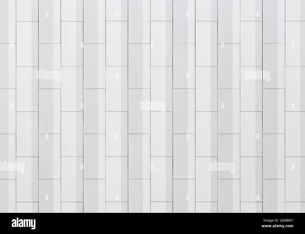 Abstract and geometric white wall viewed from the front. Modern architecture. Abstract full frame background. Copy space. Stock Photo