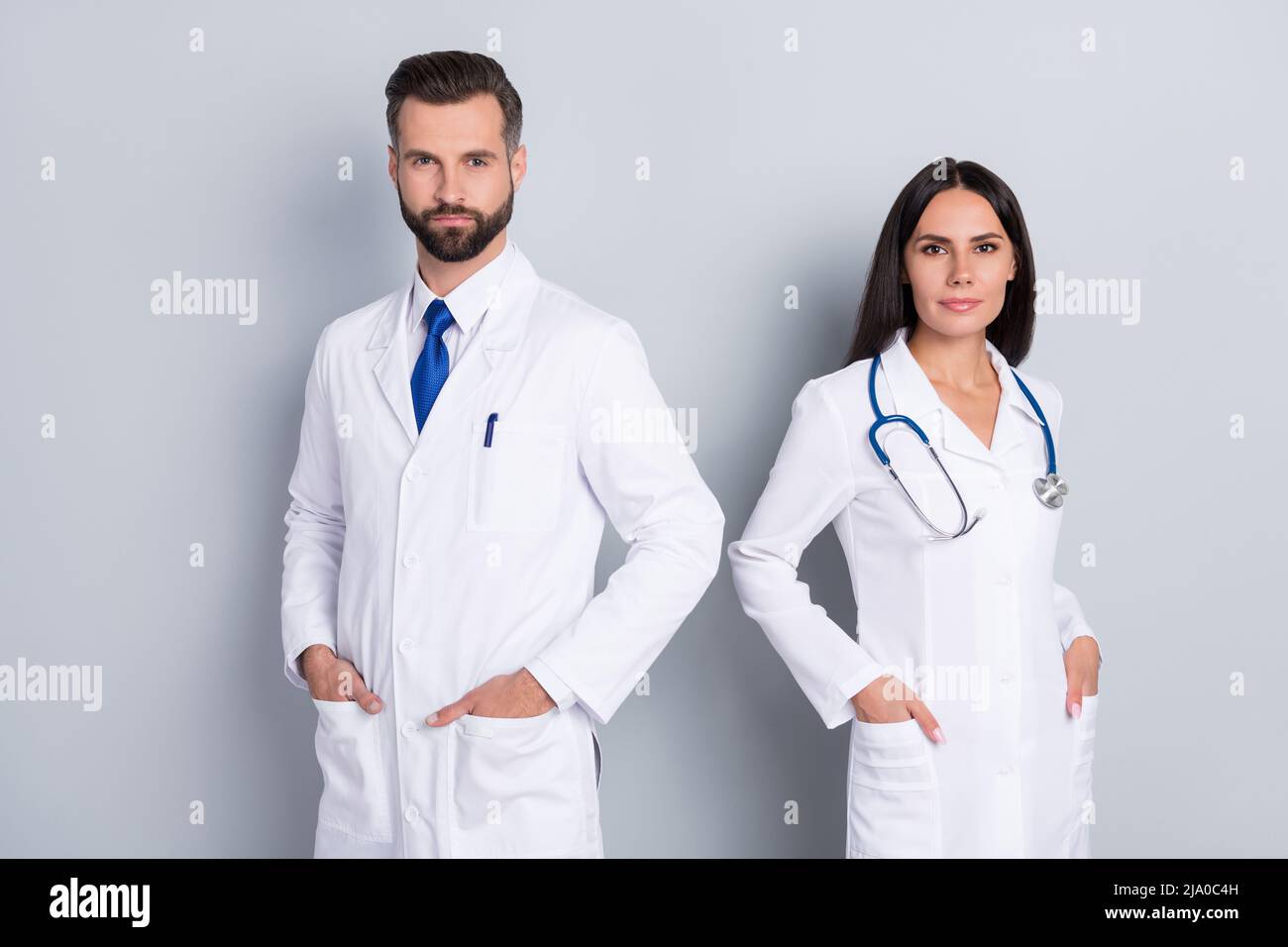 Photo of intelligent confident two doctors wear white coats arms