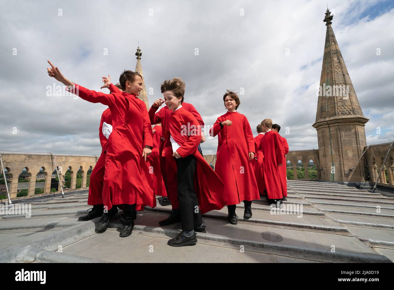 Choristers from the Choir of St John's College, Cambridge, take in the view before performing the Ascension Day carol from the top of the Chapel Tower at St John's College, a custom dating back to 1902. Picture date: Thursday May 26, 2022. Every year on Ascension Day the Choir ascends the 163ft Chapel Tower and sings the Ascension Day carol. This custom dates from 1902 and was begun by the then Director of Music, Cyril Rootham, following a conversation with Sir Joseph Larmor. Sir Jospeh was insistent that a choir singing from the tower would not be heard from the ground. Rootham was keen to pr Stock Photo